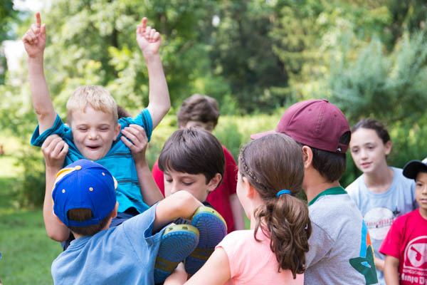 Summer campers complete a challenge requiring teamwork and problem solving.